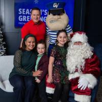 Parents with daughter and son smile with Santa and Louie